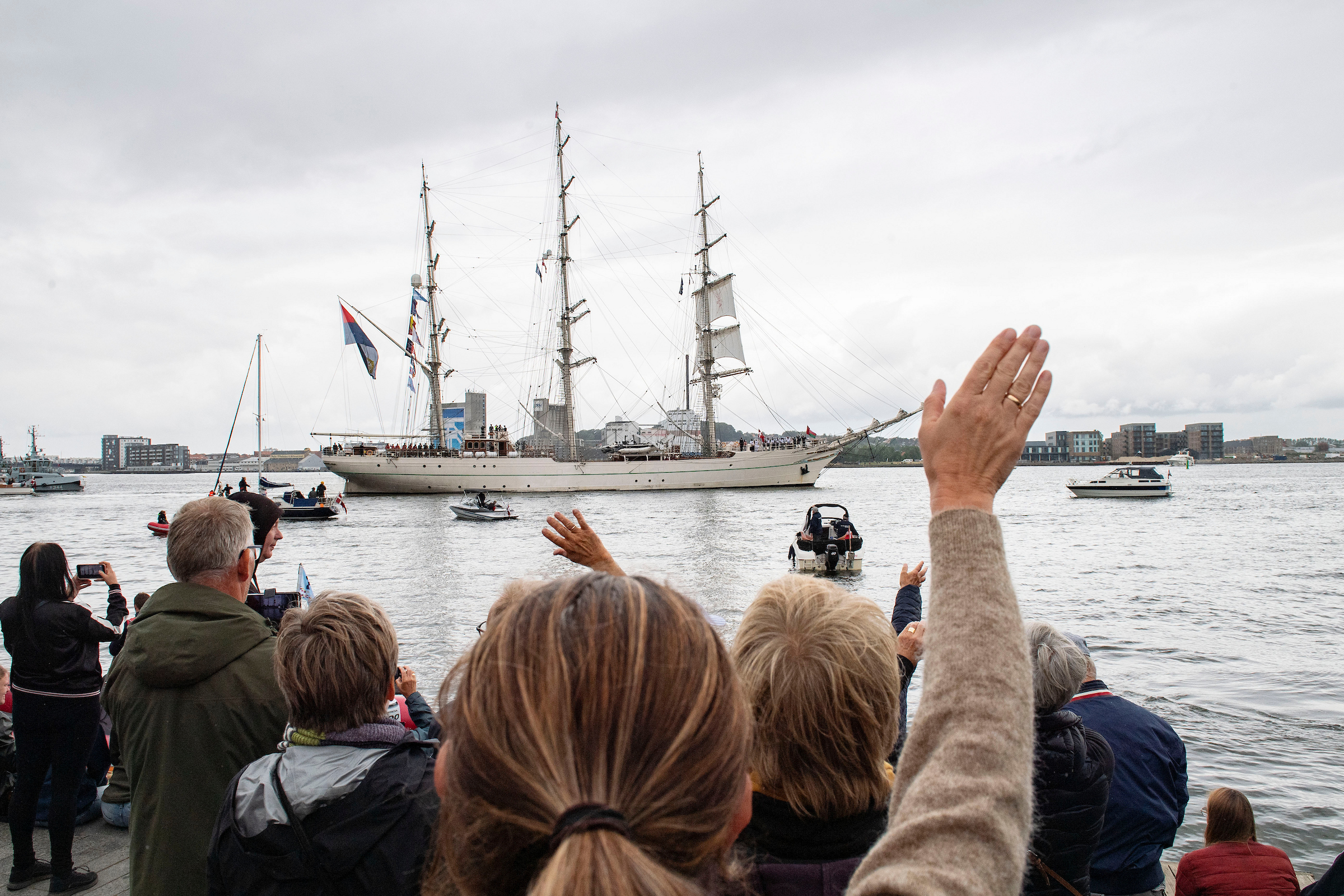 Folkemængde vinker til skibe